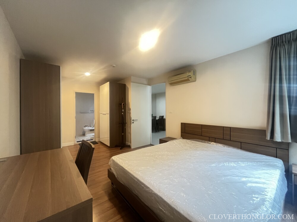 Spacious bedroom with modern furnishings.