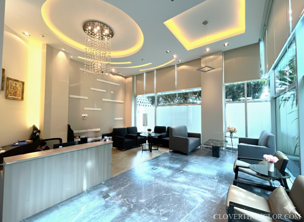 Sophisticated main reception lobby at The Clover Thonglor, featuring a modern Juristic Person desk and comfortable multi-zone resident seating areas.