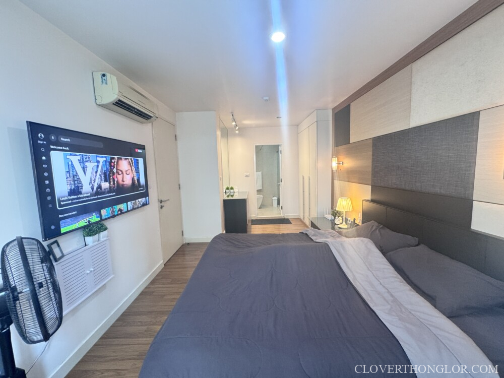 Modern bedroom with television and decor.